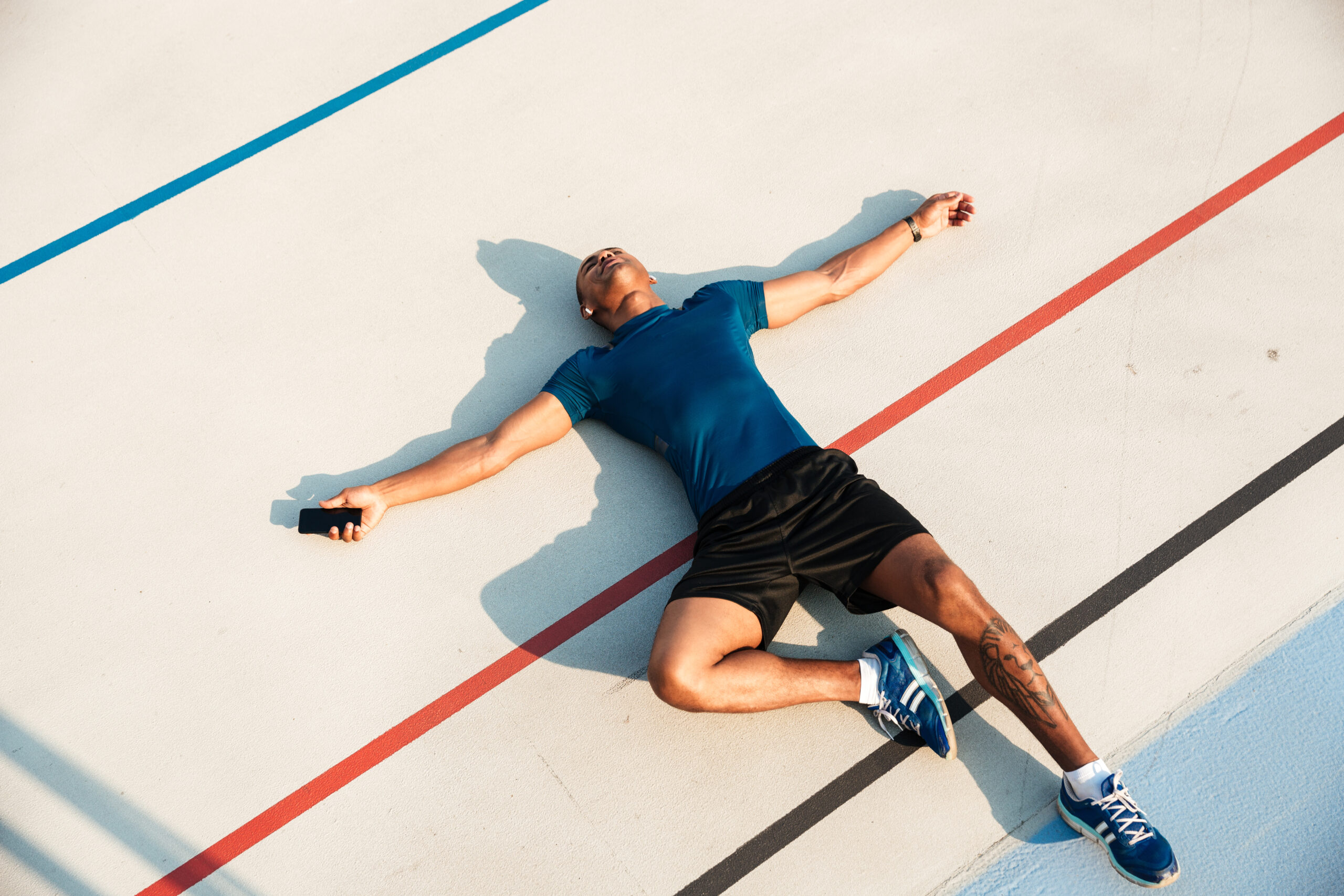 Athlete lying on a running track after intense training session